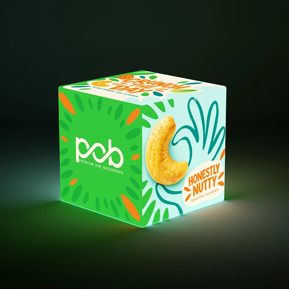 Illuminated 3D cube display featuring colorful cashew graphics and branded panels against a dark background